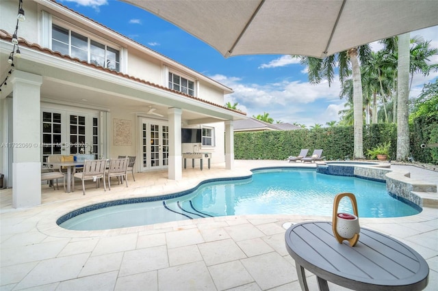 view of swimming pool with an in ground hot tub, ceiling fan, french doors, and a patio