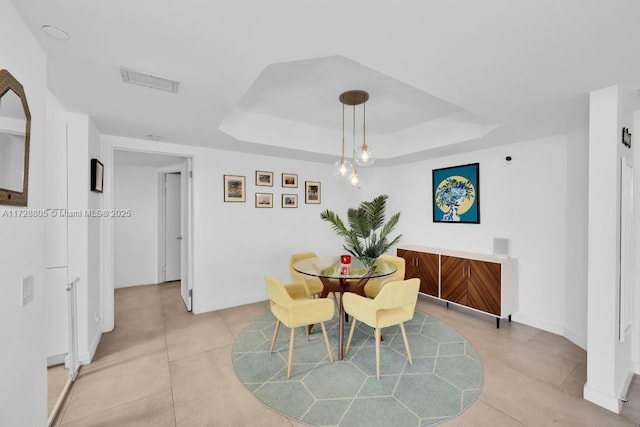 dining space with a raised ceiling