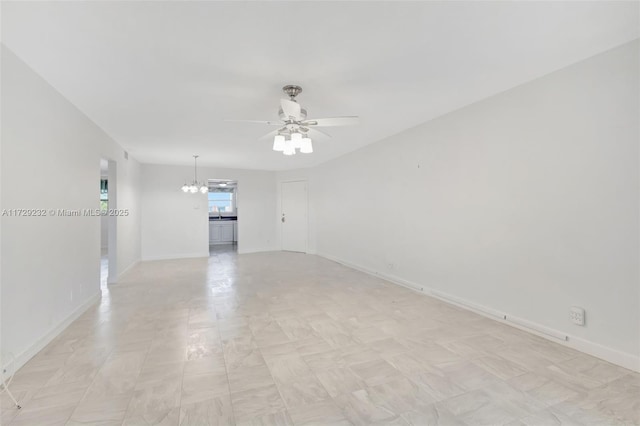 spare room with ceiling fan with notable chandelier