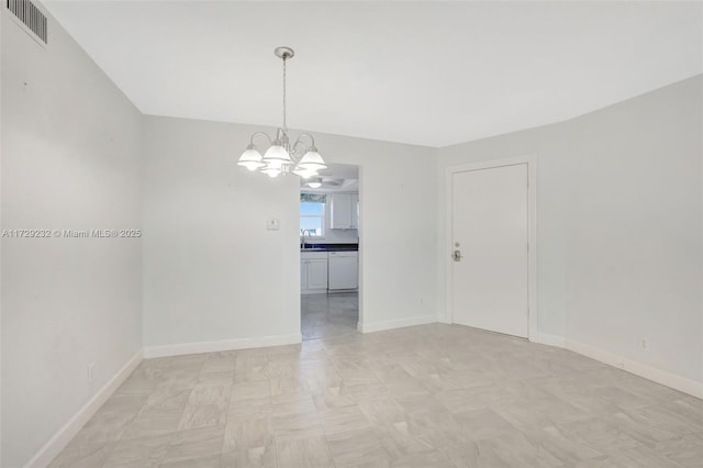 spare room with sink and an inviting chandelier