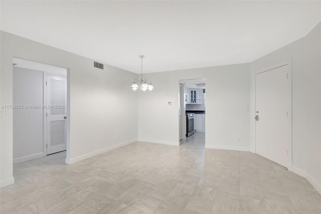 spare room featuring a chandelier