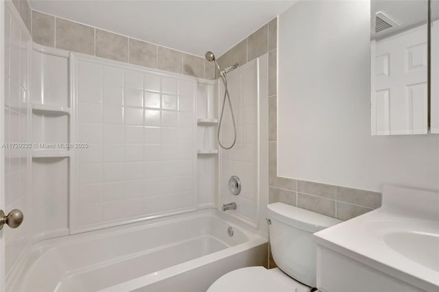 full bathroom with tile walls, toilet, vanity, and tiled shower / bath