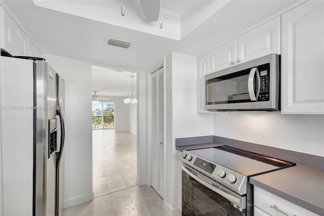 kitchen featuring ceiling fan, white cabinetry, light tile patterned floors, and stainless steel appliances