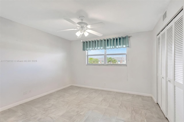 unfurnished bedroom with ceiling fan and a closet