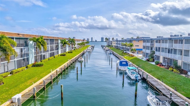 surrounding community with a water view, a dock, and a yard