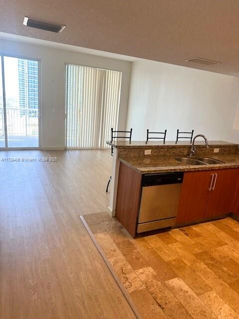 kitchen featuring dishwasher, sink, and light hardwood / wood-style flooring