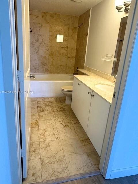 full bathroom featuring toilet, tiled shower / bath combo, and vanity