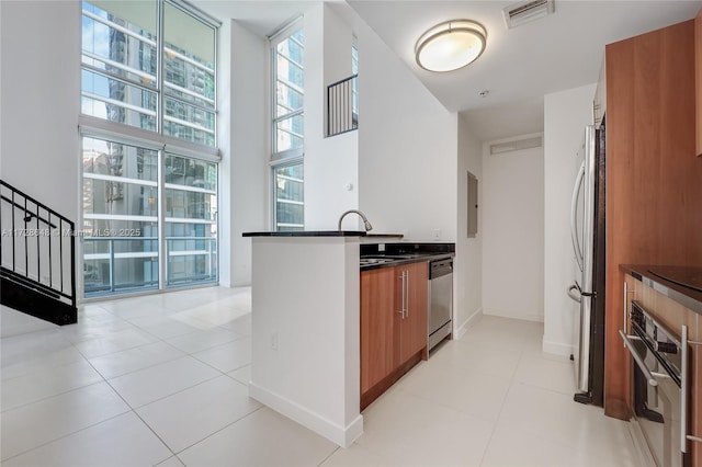 kitchen with sink, electric panel, stainless steel appliances, and light tile patterned floors