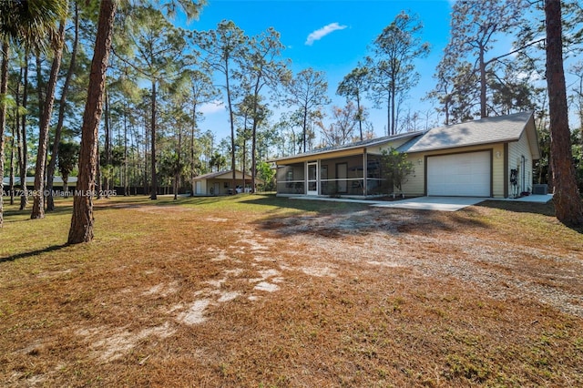 view of front of home with a front lawn, a garage, and a sunroom