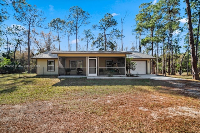 view of front of property featuring a front yard, a garage, and a sunroom