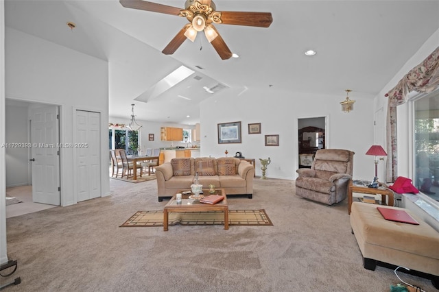 carpeted living room with ceiling fan and high vaulted ceiling