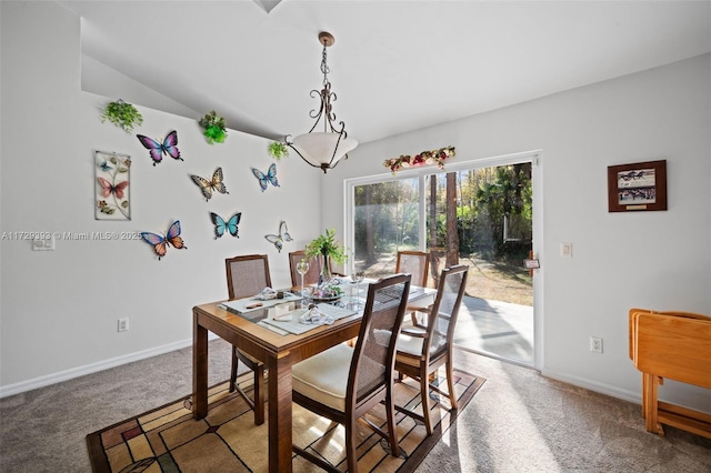 carpeted dining room with vaulted ceiling