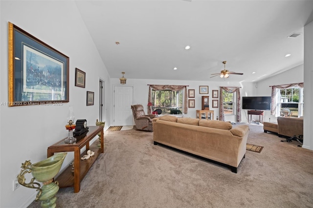 living room with ceiling fan, light colored carpet, and vaulted ceiling