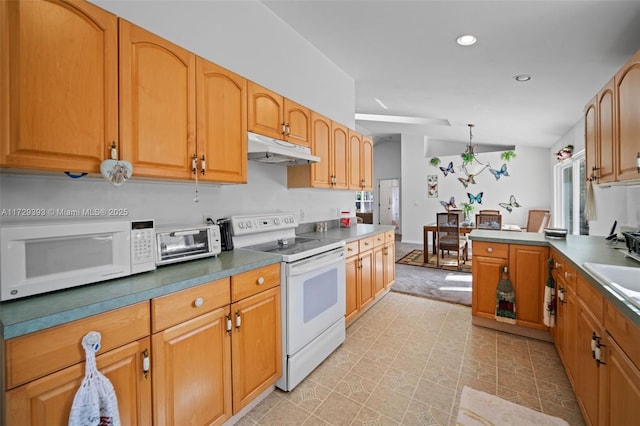 kitchen featuring sink, white appliances, and hanging light fixtures