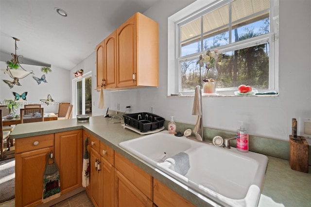 kitchen featuring plenty of natural light, pendant lighting, sink, and kitchen peninsula