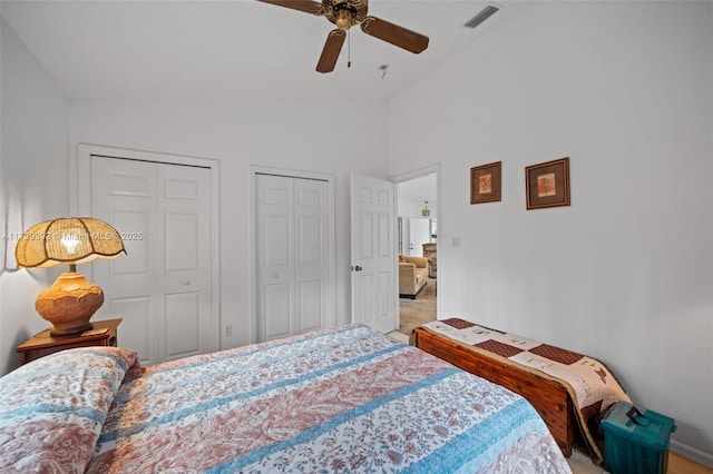 bedroom featuring vaulted ceiling, ceiling fan, and two closets