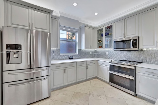 kitchen featuring decorative backsplash, appliances with stainless steel finishes, gray cabinetry, and ornamental molding