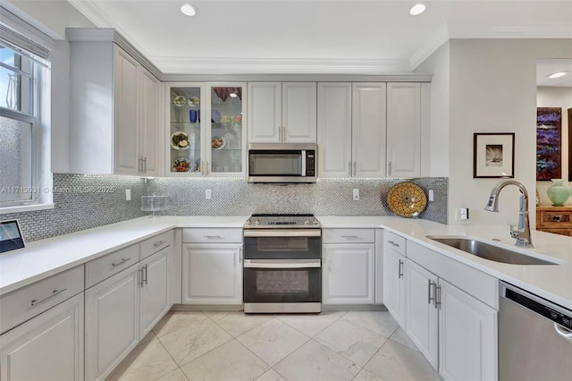 1033 NE 17th Way Unit 704, Fort Lauderdale, FL 33304 - kitchen featuring stainless steel appliances, light marble finish floors, tasteful backsplash, ornamental molding, and glass insert cabinets