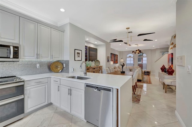 1033 NE 17th Way Unit 704, Fort Lauderdale, FL 33304 - kitchen with appliances with stainless steel finishes, open floor plan, a ceiling fan, a peninsula, and backsplash