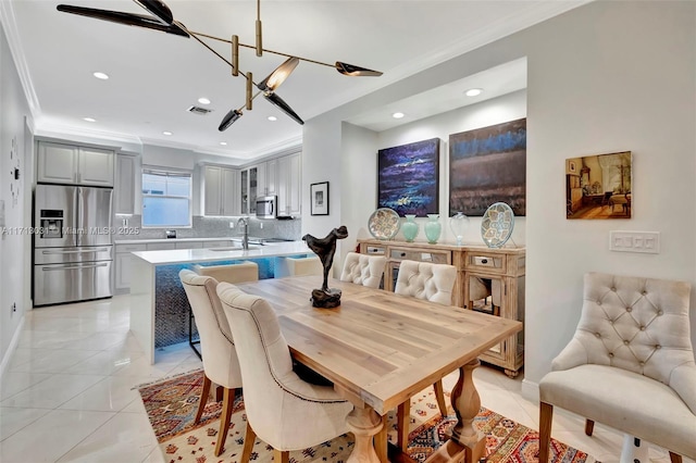 tiled dining room with sink and crown molding