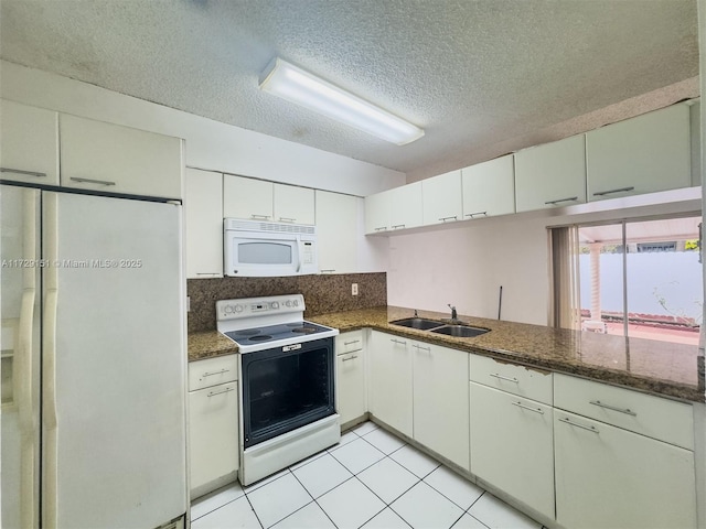 kitchen with dark stone counters, sink, white appliances, and white cabinetry