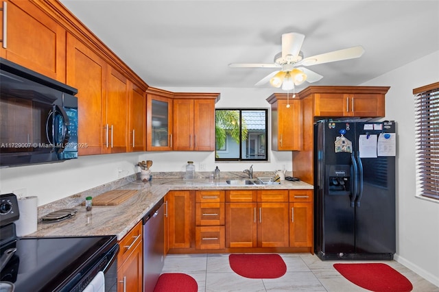 kitchen featuring black appliances, light stone countertops, light tile patterned floors, sink, and ceiling fan