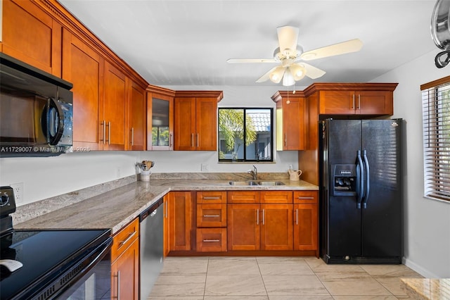 kitchen with sink, a wealth of natural light, light stone counters, and black appliances