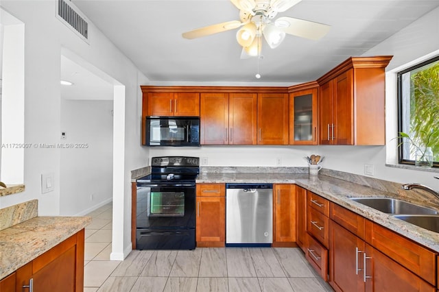 kitchen featuring light stone counters, ceiling fan, sink, and black appliances