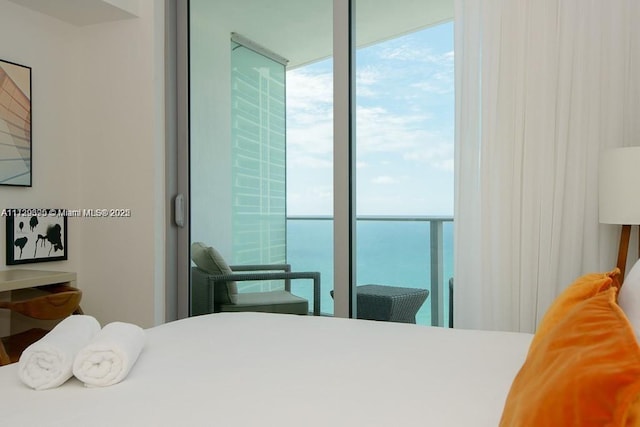 bedroom with a water view and multiple windows