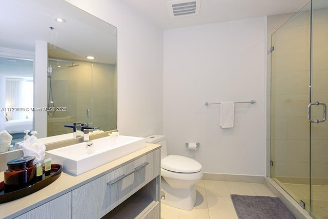 bathroom featuring toilet, vanity, tile patterned flooring, and walk in shower