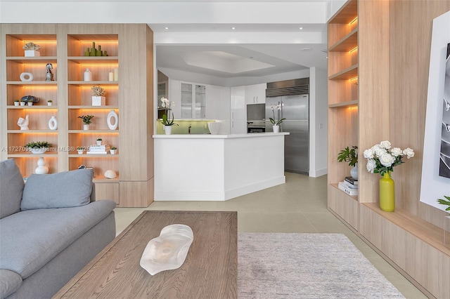 living room with built in features and a tray ceiling