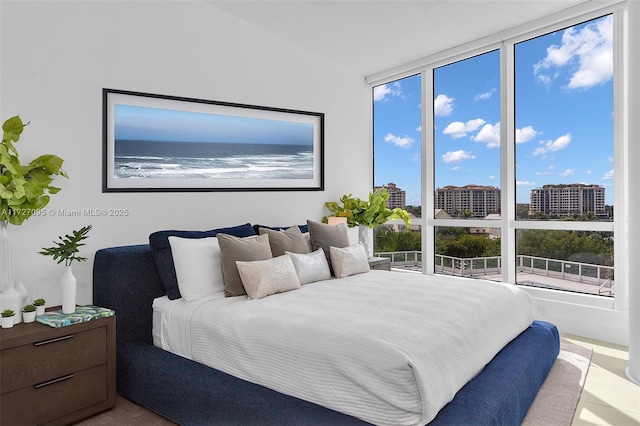 bedroom with a water view and expansive windows