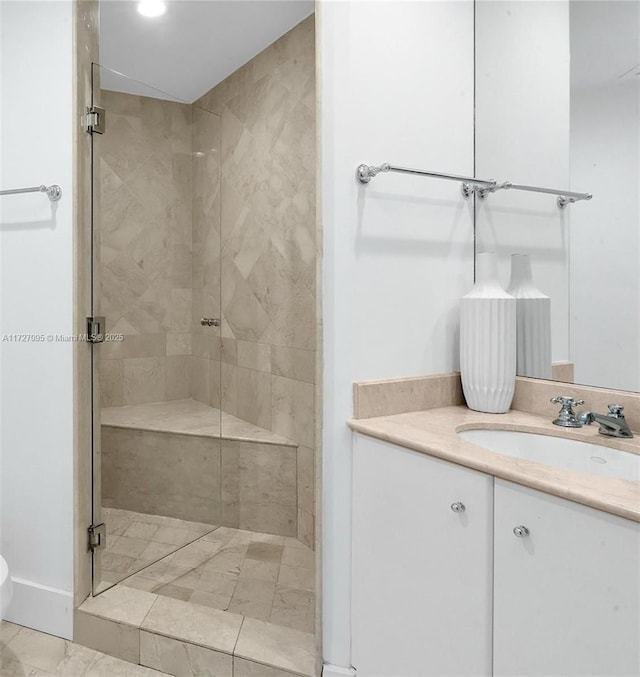 bathroom featuring a shower with door and vanity