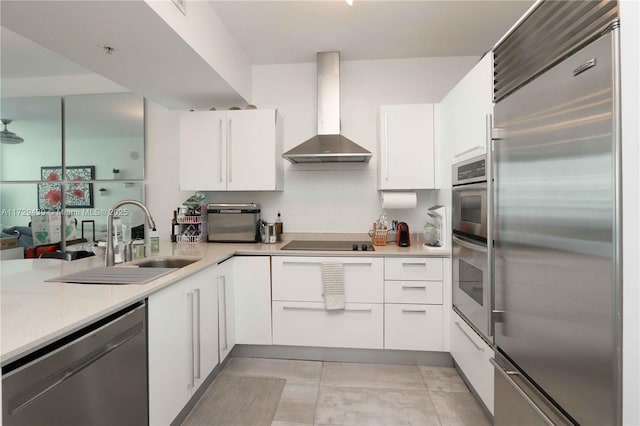 kitchen featuring sink, white cabinetry, wall chimney range hood, and stainless steel appliances