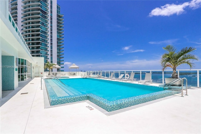 view of swimming pool featuring a patio area and a water view