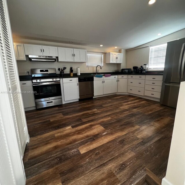 kitchen with stainless steel appliances, sink, white cabinets, and dark hardwood / wood-style floors