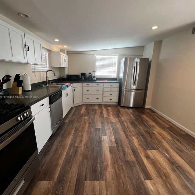 kitchen with stainless steel appliances, white cabinetry, sink, and dark wood-type flooring