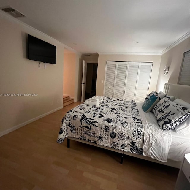 bedroom featuring ornamental molding, hardwood / wood-style floors, and a closet