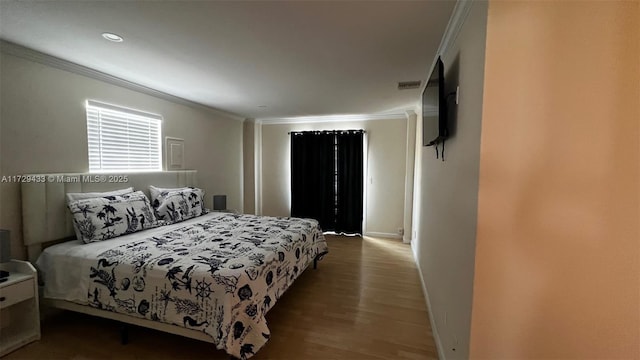 bedroom featuring crown molding and wood-type flooring