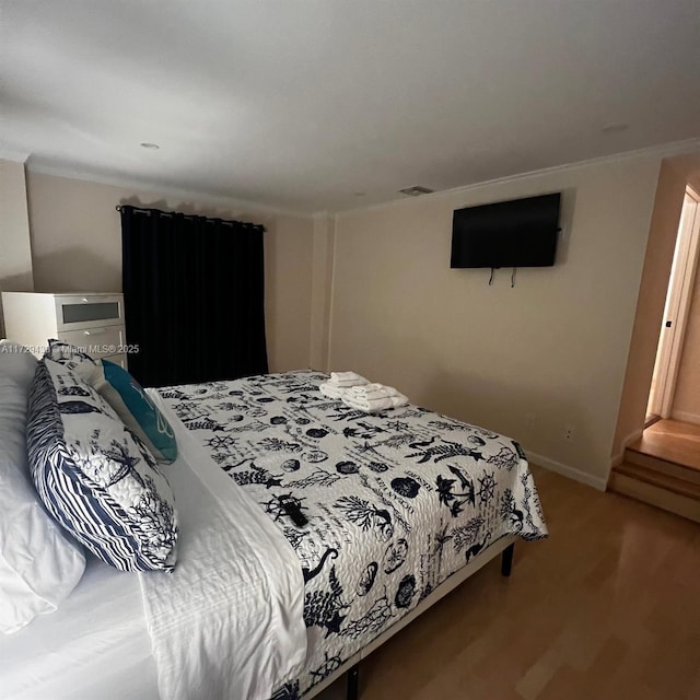 bedroom with crown molding and wood-type flooring