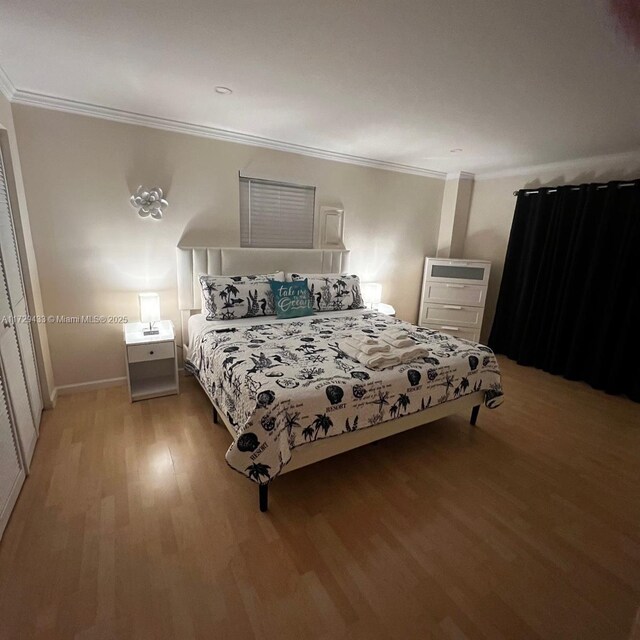 bedroom with crown molding and light hardwood / wood-style floors