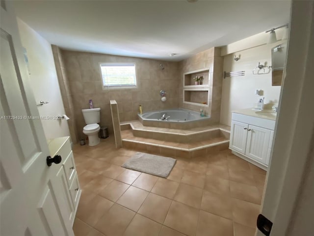 bathroom with tile patterned flooring, tile walls, a relaxing tiled tub, vanity, and toilet