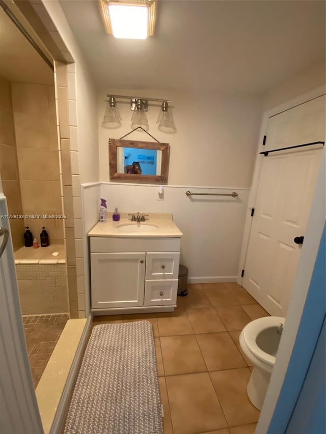 bathroom with vanity, tile patterned floors, toilet, and a tile shower