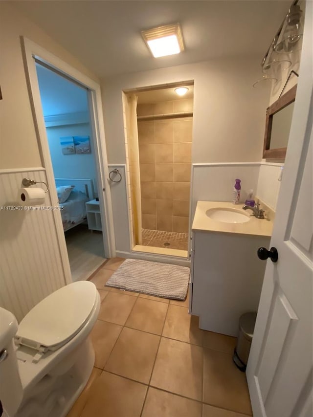 bathroom with vanity, tiled shower, tile patterned floors, and toilet