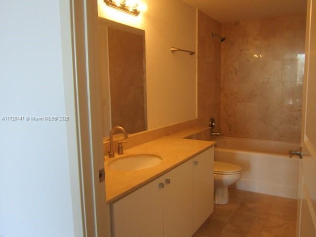 full bathroom featuring tile patterned floors, toilet, vanity, and tiled shower / bath combo