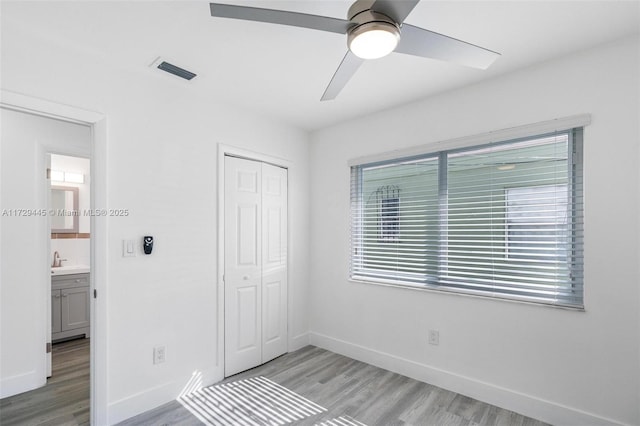 unfurnished bedroom with ceiling fan, a closet, and light hardwood / wood-style floors