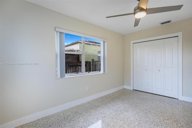 unfurnished bedroom with ceiling fan and a closet