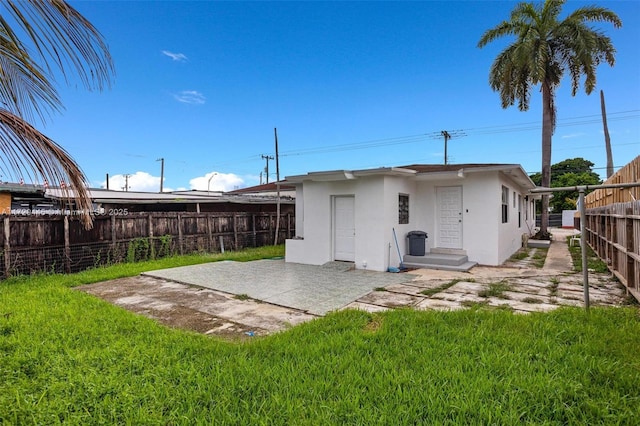 back of property featuring a lawn and a patio