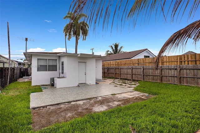 back of house with a lawn and a patio area