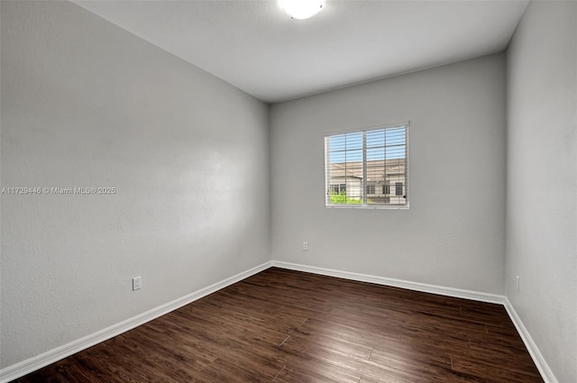 unfurnished room with dark wood-type flooring